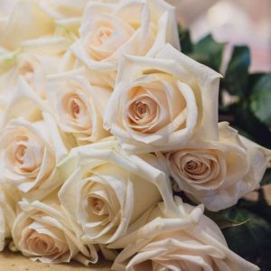 a bouquet of white roses sitting on top of a table